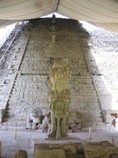 A long brick stairway and a free-standing sculpture in front of it, covered with a white tent.