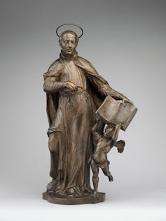 A statue of Saint Ignatius Loyola with an angel holding a book.